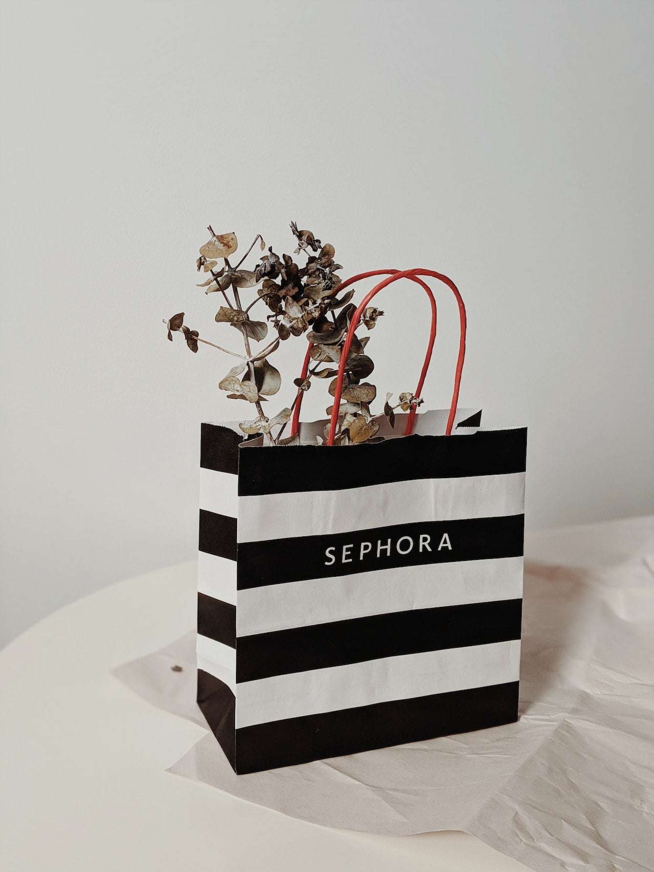 black and white stripped Sephora bag with a plant inside