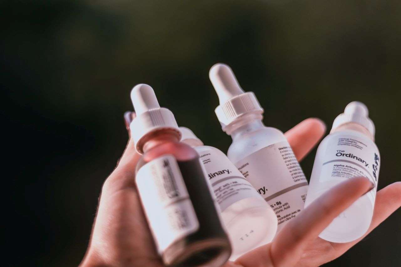 Four bottles of the Ordinary skincare brand held in one hand