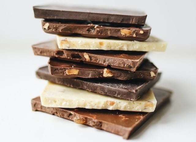 Blocks of various types of chocolate on top of eachother from milk, dark and white chocolate