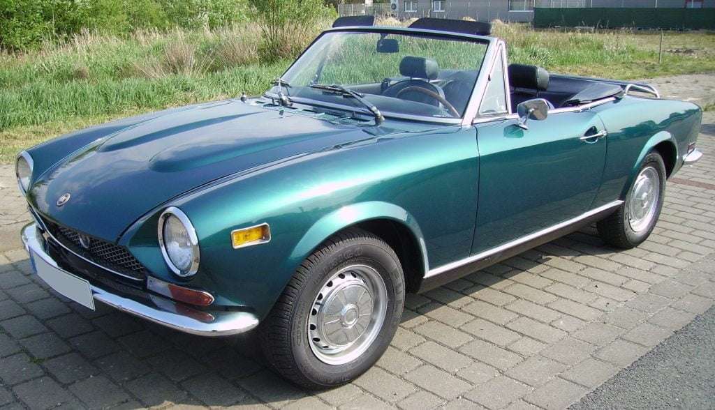 a turquoise fiat spider cabriolet parked on the street