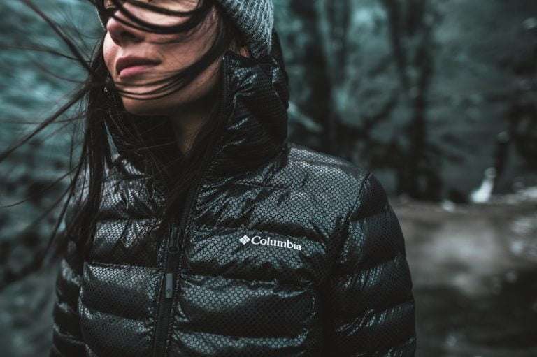 Woman wearing a Colombia jacket in the rain in the forest
