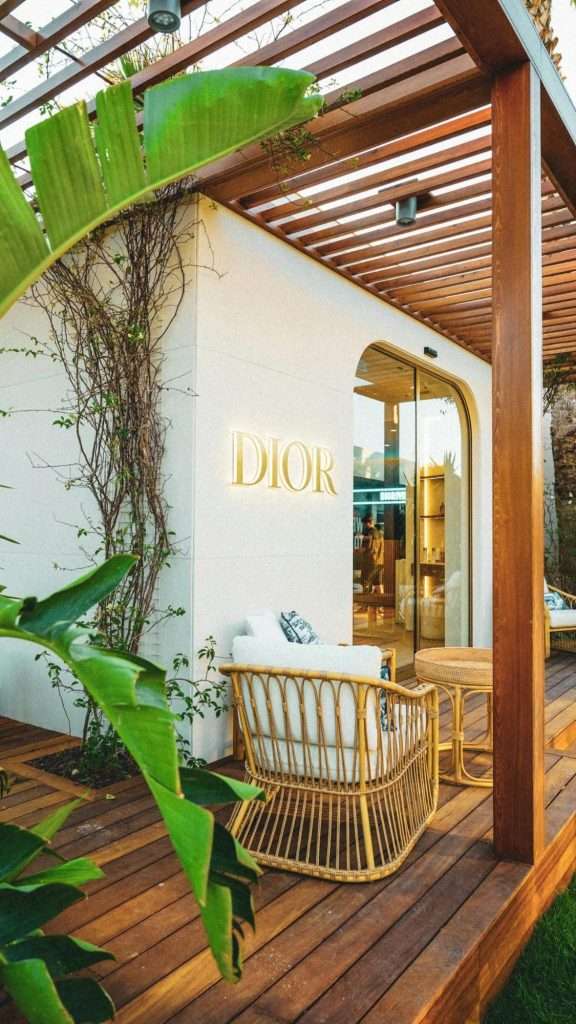 Image of House of Dior, Dior logo on wall setting of a patio with Dior logo