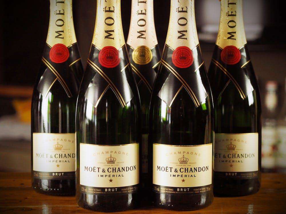 Five bottles of champagne standing on a table. The champagne brand is Moët & Chandon or Moet