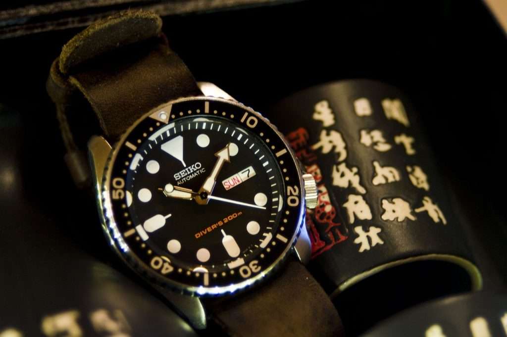 seiko watch with a black dial in a box with Japanese cup