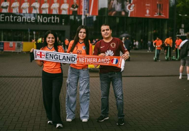 UEFA European Football Champions in Germany three fans holding the england versus The Netherlands Semi final scarf in Germany