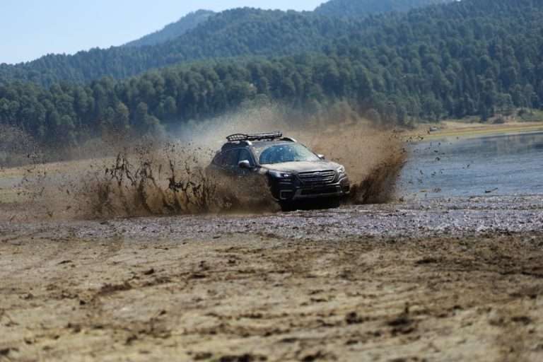 Subaru off-roading in mud and river