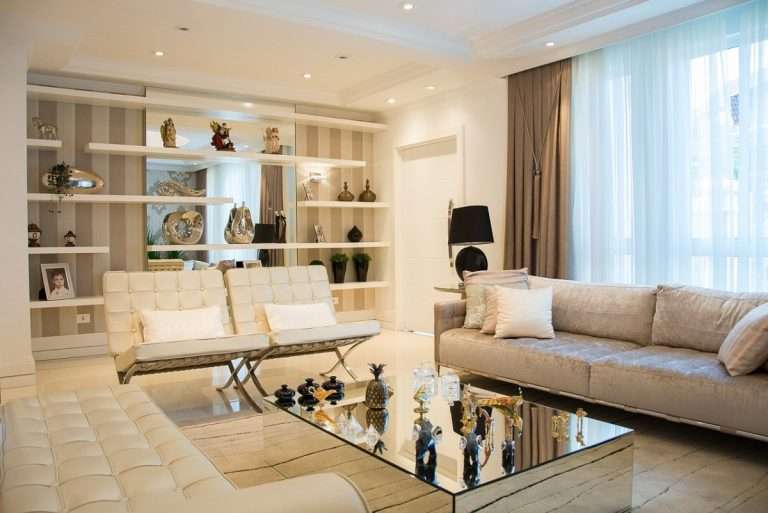 White Barcelona Chairs in the living room and a grey sofa