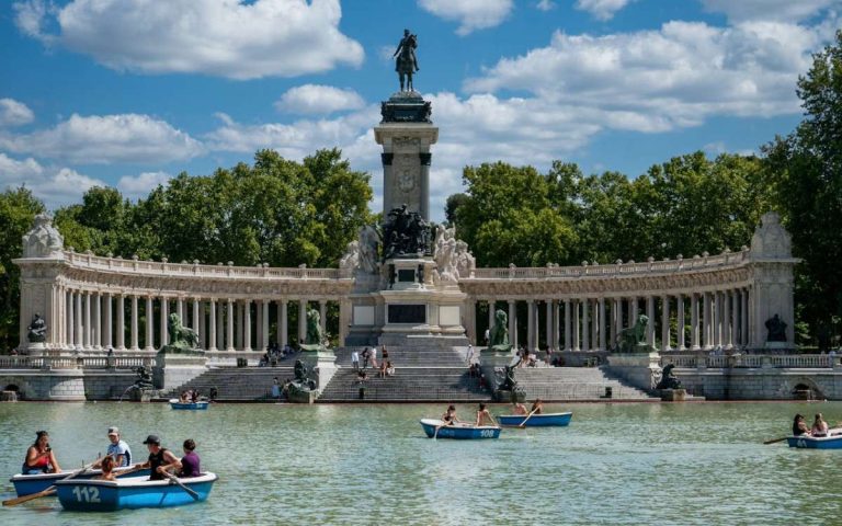 retiro park in madrid at the lake people rowing